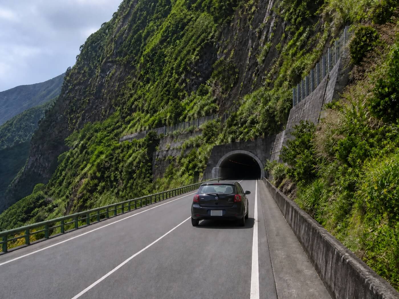 Voiture approchant un tunnel sur une route de montagne à Madère